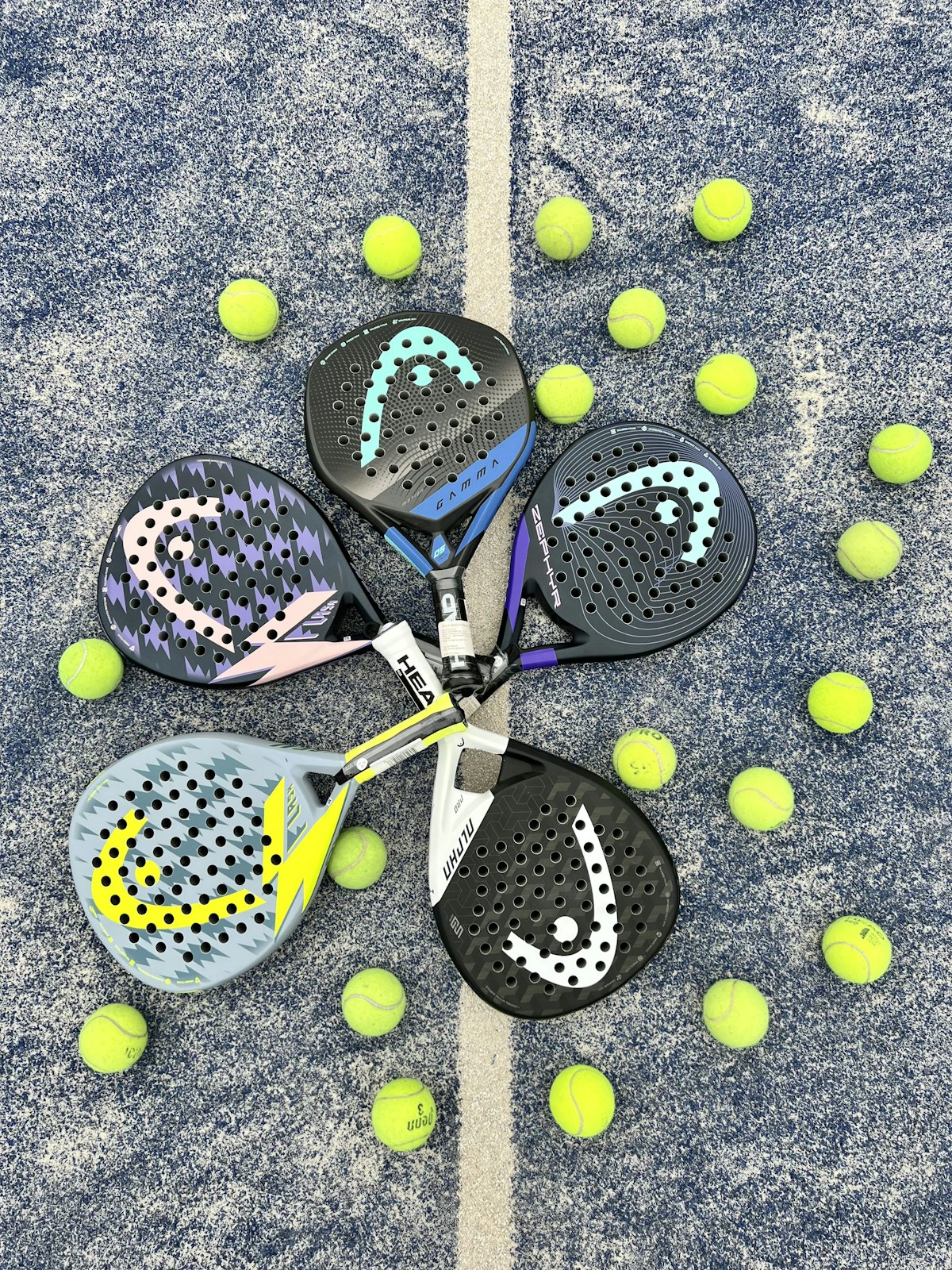 Padel rackets and balls laid out on a blue court