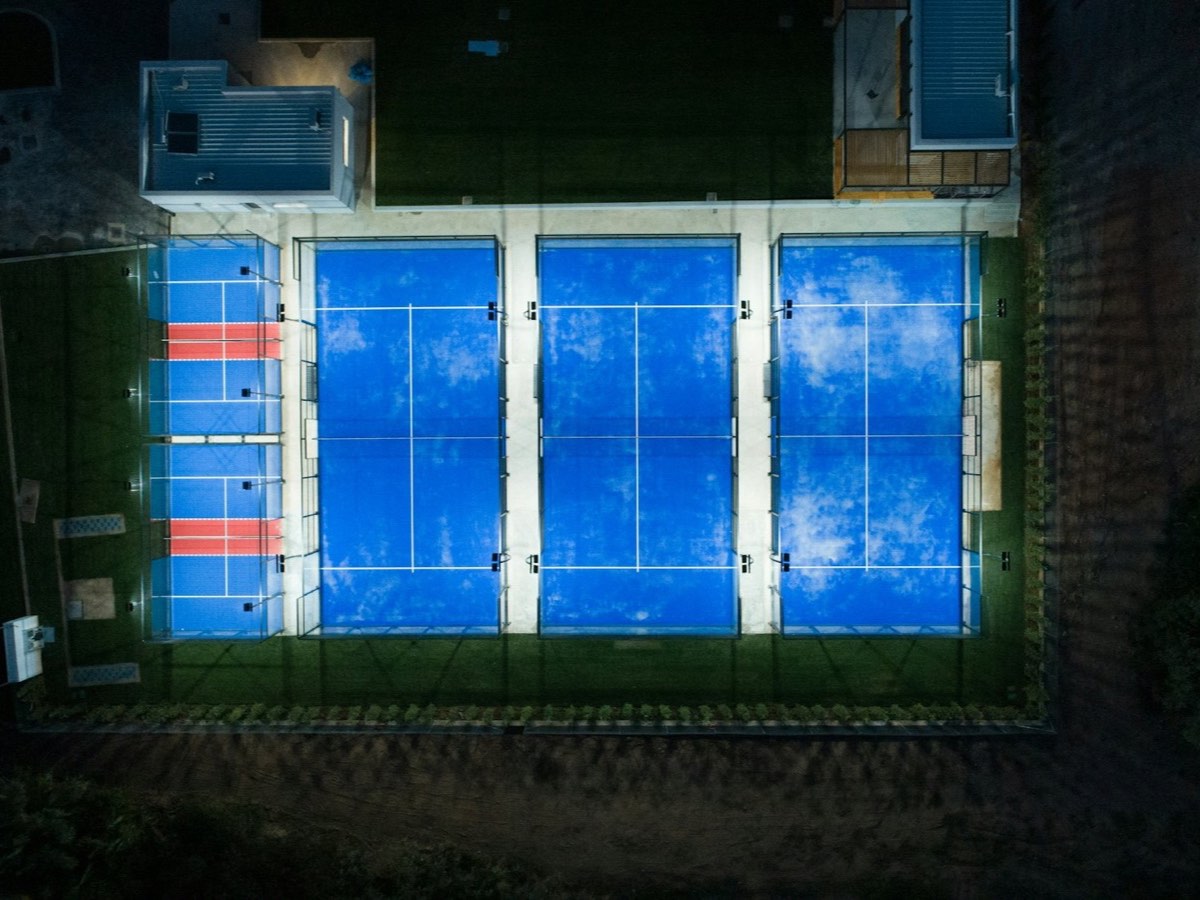 Aerial night view of a row of blue padel courts